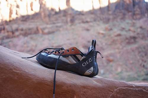 rock climbing black and white shoes place on rock formation clothing